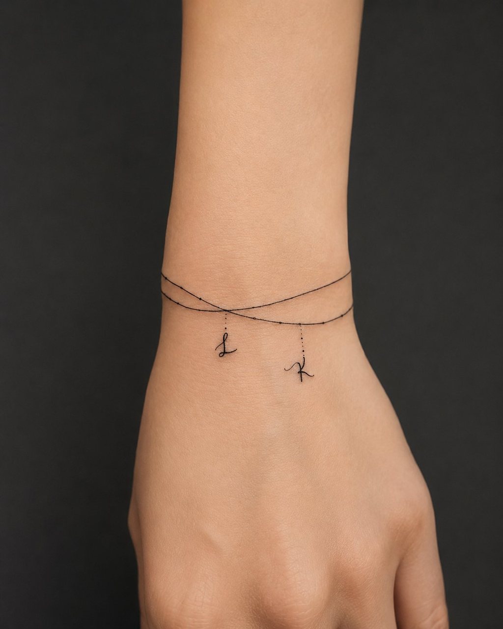 Mini tattoo Esbjerg – elegant fineline armbånd-tatovering på håndled med initialer